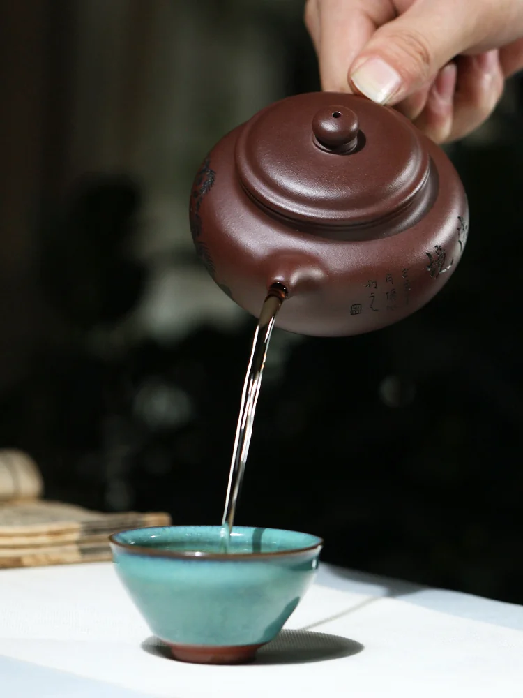 Jian Ru Jia Jing teapot pouring tea into a turquoise cup